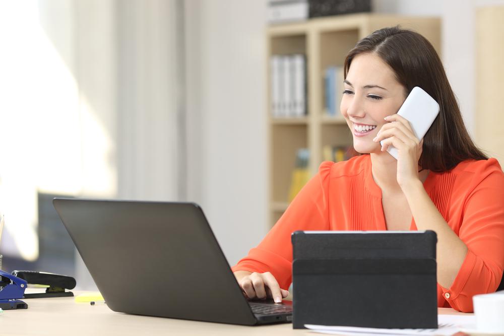 A VoIP phone system that's packed with a host of essential features is an important part of any home office setup. entrepreneur taking a call in a home office